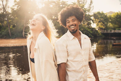 a man and a woman are walking along the water