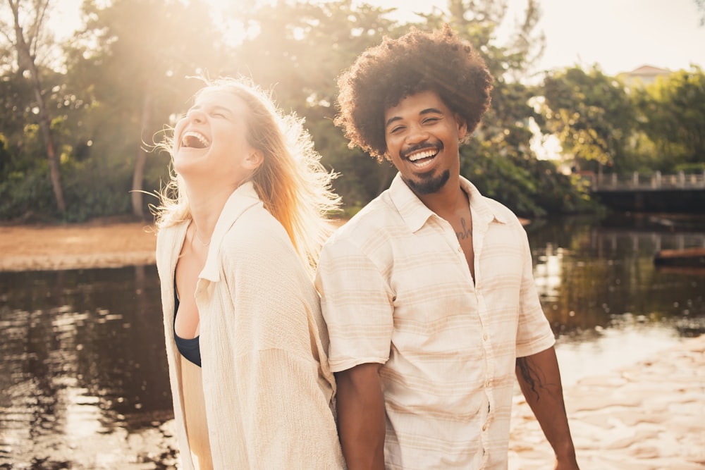 a man and a woman are walking along the water