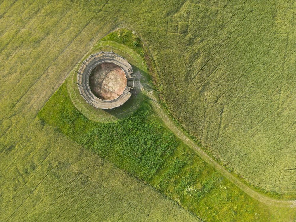 an aerial view of a round structure in a field