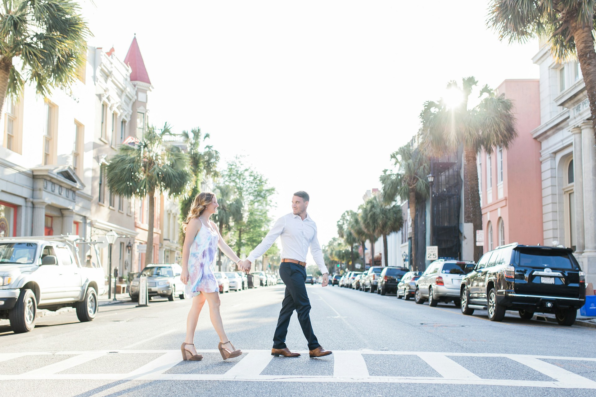 A happy couple walking hand-in-hand along a palm tree-lined street in a Florida neighborhood, enjoying their new surroundings.