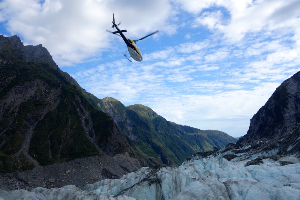 Un avión sobrevolando un glaciar con montañas al fondo