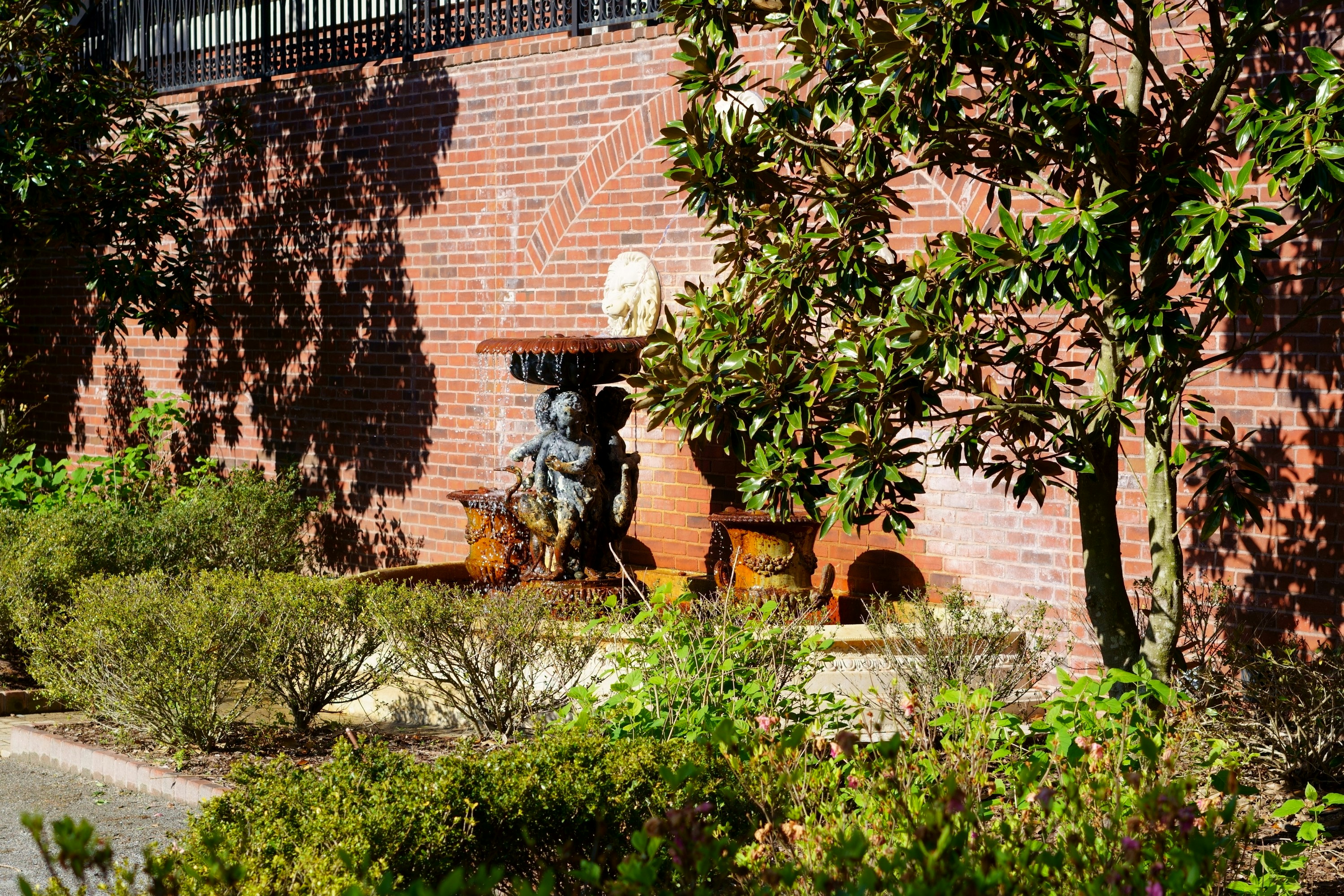 a brick building with a statue in the middle of it, A spring stroll around the Alpharetta gardens.