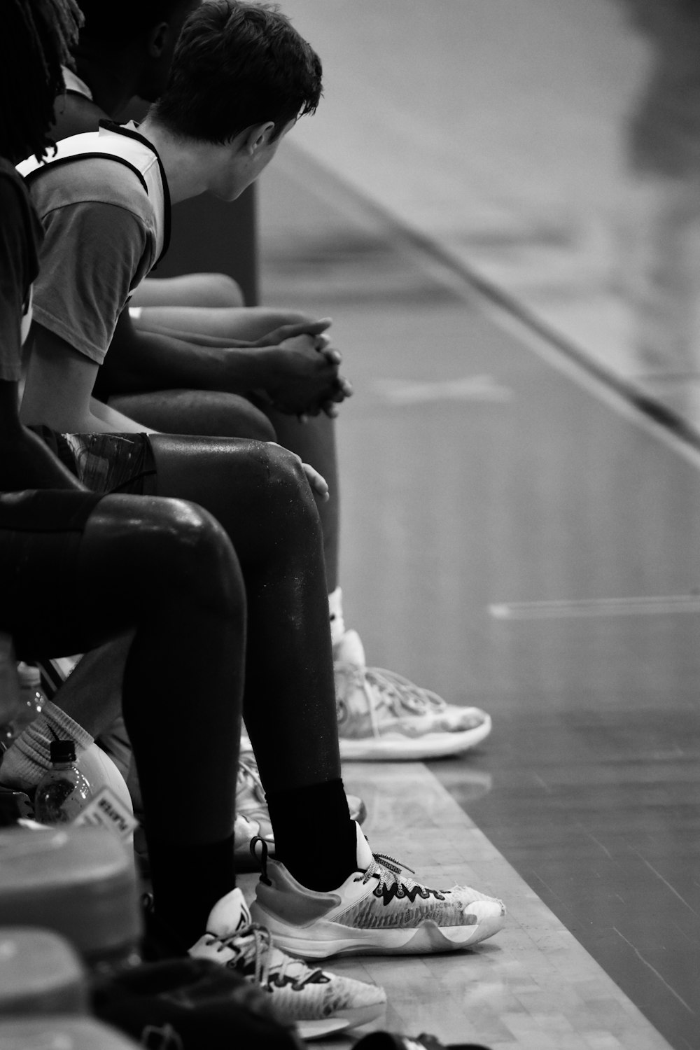 a group of young men sitting on top of a basketball court