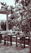 Serene outdoor patio with comfortable chairs and lush greenery.