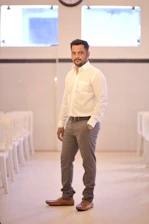 Man wearing a minimalist white Percy t-shirt standing confidently in a bright, clean space.