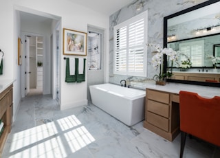 a bathroom with a tub, sink, and mirror