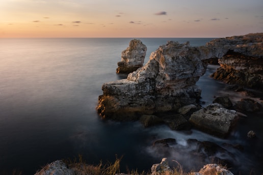 A pastel-hued Mediterranean coastal scene with soft sunlight over calm waters, evoking the serene vibe of le coquers.