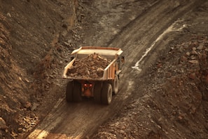 a dump truck driving down a dirt road