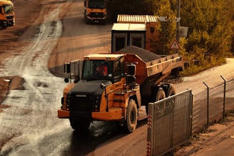 a dump truck driving down a dirt road