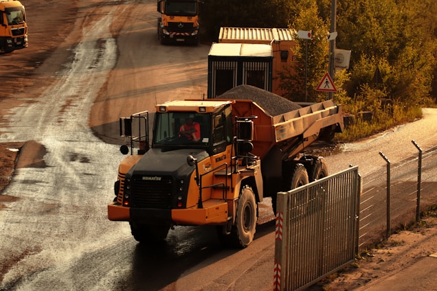 a dump truck driving down a dirt road