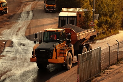 a dump truck driving down a dirt road