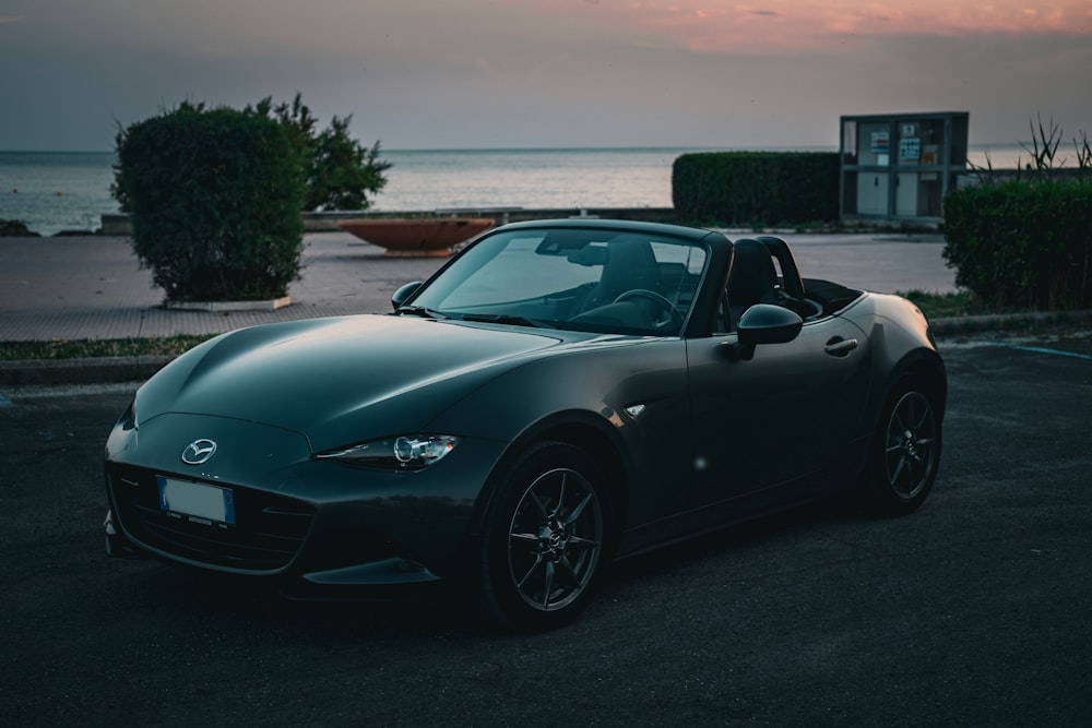 a car parked in a parking lot next to the ocean