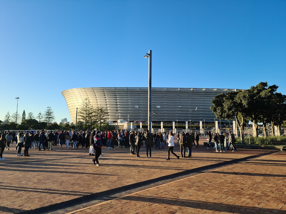 uma multidão de pessoas caminhando ao redor de um estádio