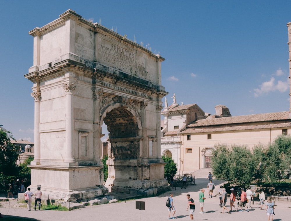 a group of people standing around a stone arch