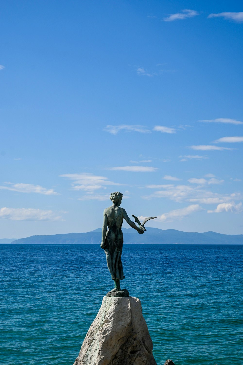 eine Statue eines Mannes, der auf einem Felsen steht