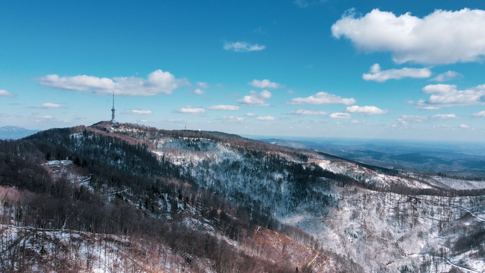 a snowy mountain with a radio tower on top of it