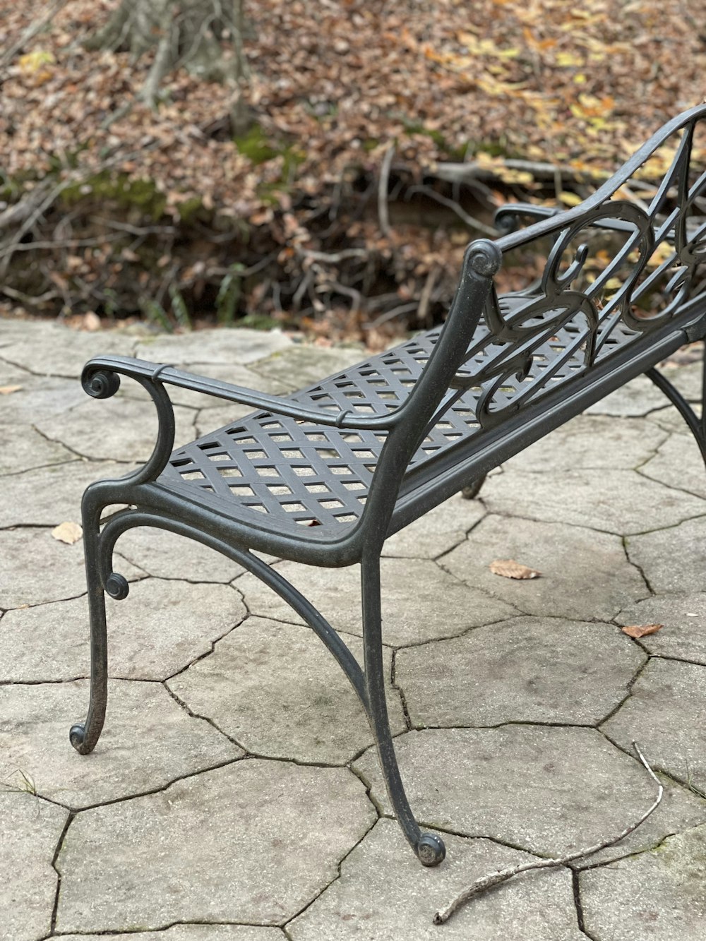 a metal bench sitting on top of a stone floor