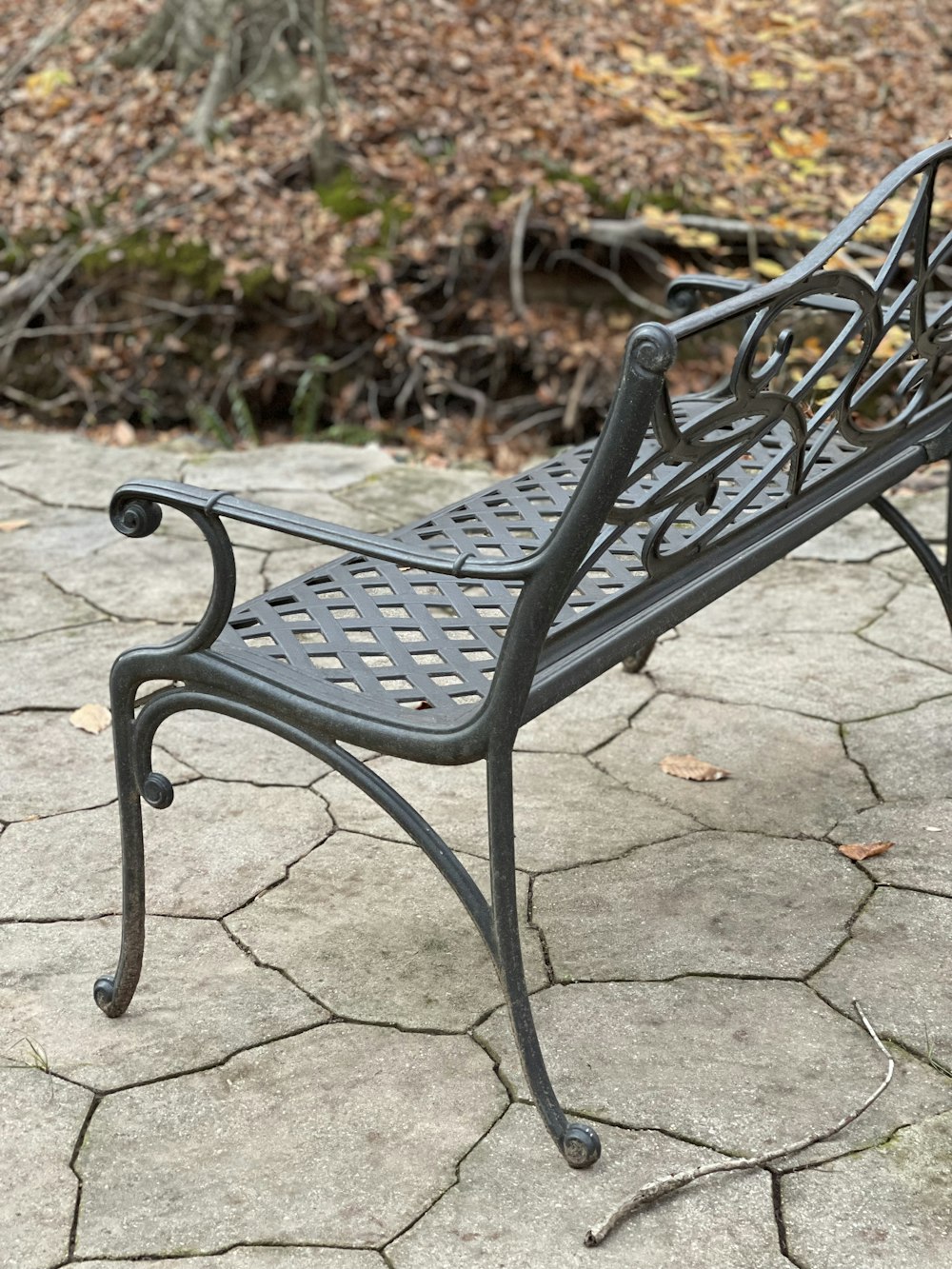 un banc métallique posé sur un sol en pierre