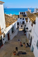 a group of people sitting on top of a cobblestone street