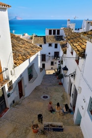 a group of people sitting on top of a cobblestone street
