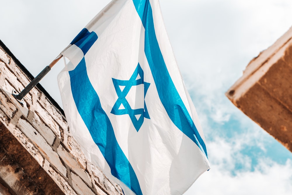 an israeli and israeli flag hanging from a brick building