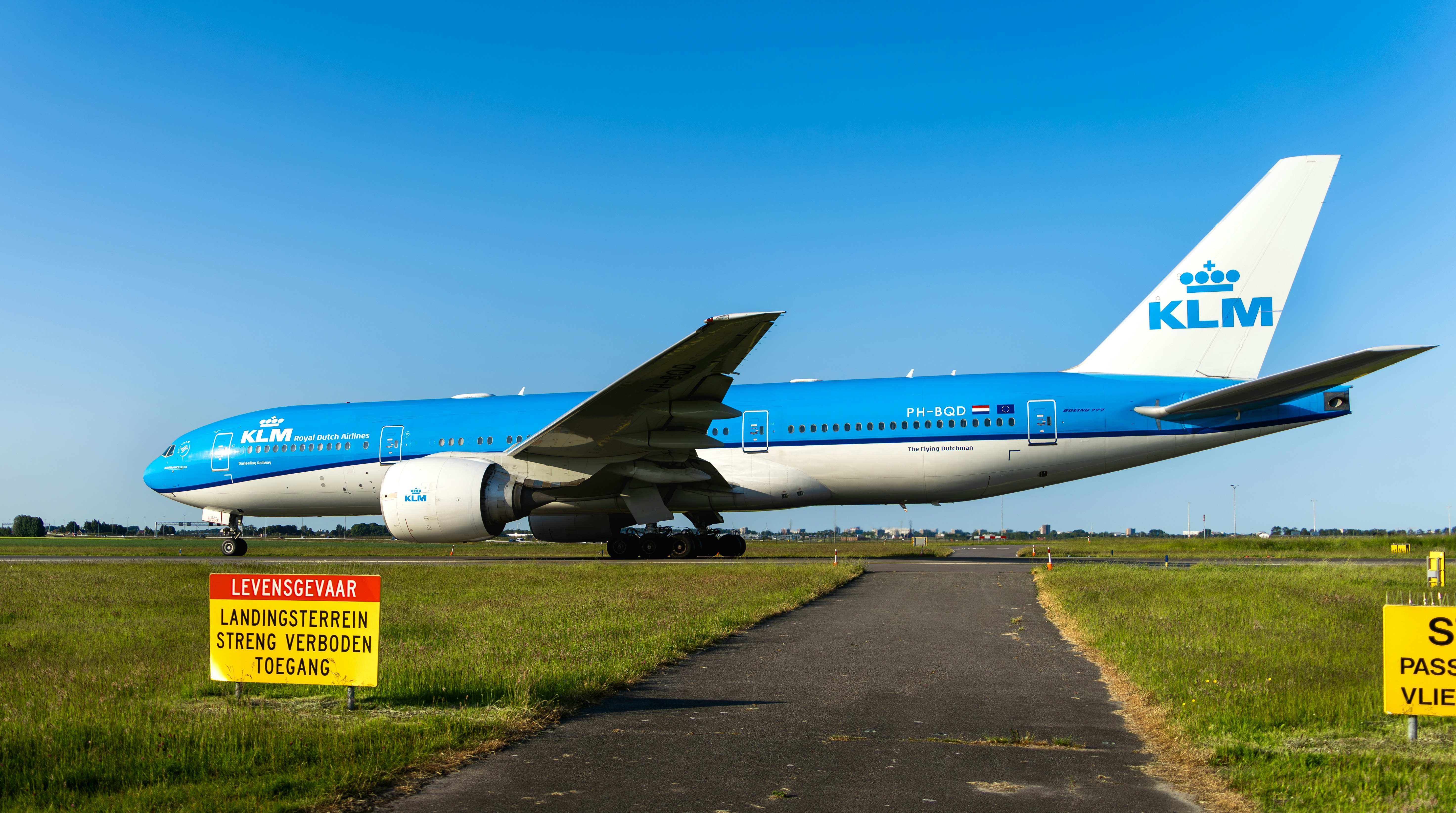 a large blue and white airplane on a runway, KLM plane driving on the runway at Schiphol Amsterdam.