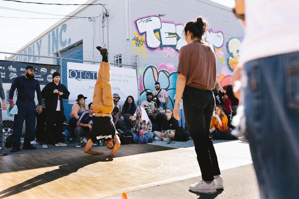 a group of people watching a man do a trick on a skateboard