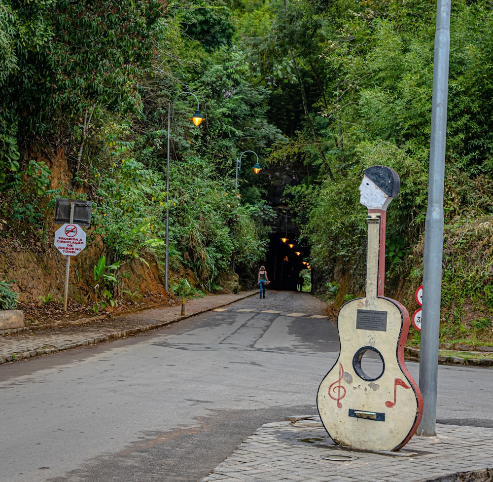 a guitar statue on the side of a road