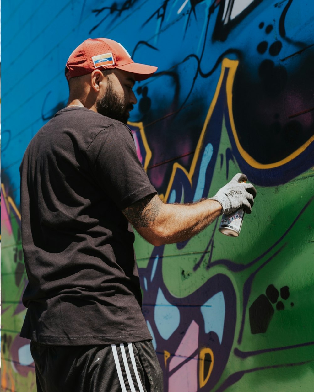 a man painting a wall with graffiti on it