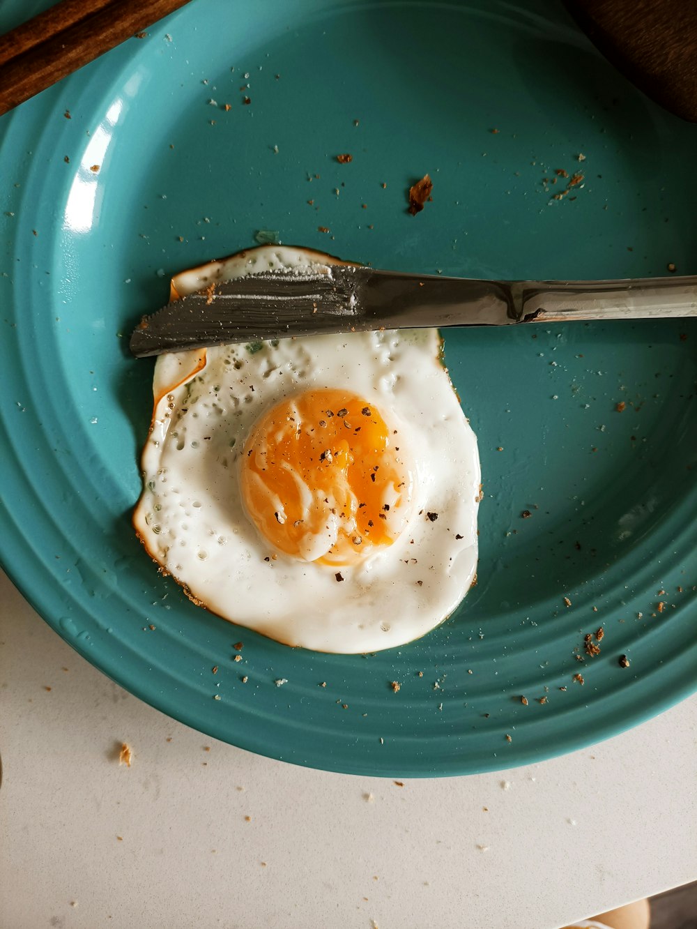 a fried egg on a plate with a knife and fork