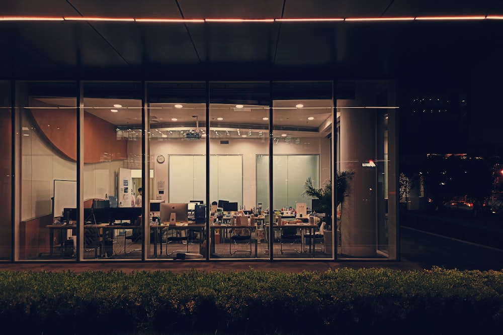 un immeuble de bureaux aux murs de verre la nuit avec vue sur la ville