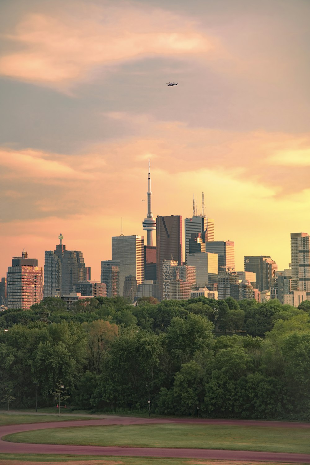 a city skyline with a plane flying in the sky