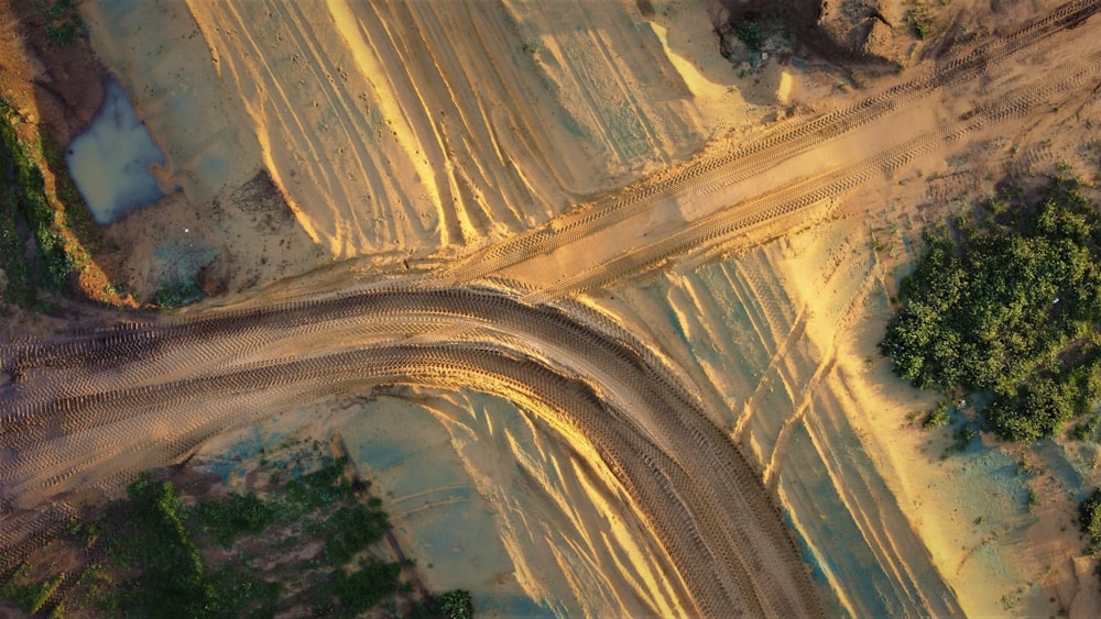 an aerial view of a dirt road in the middle of a forest