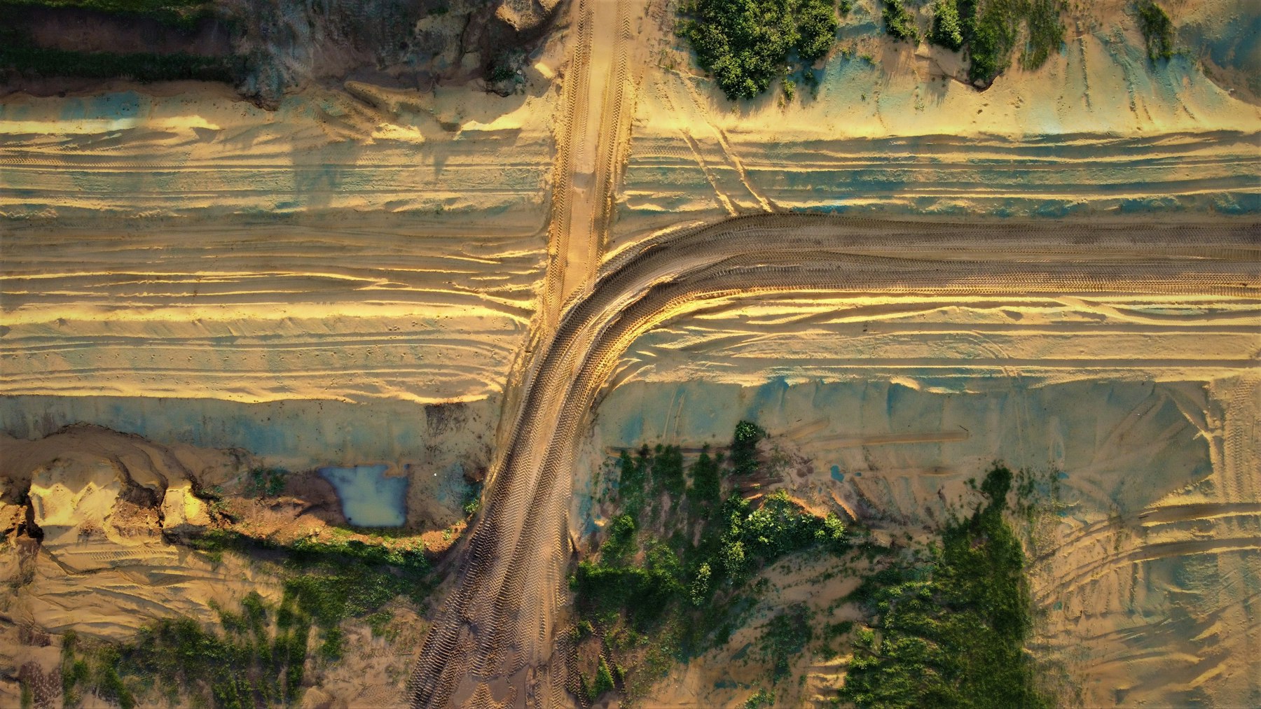 Aerial view of a dirt trail cutting through mountain terrain