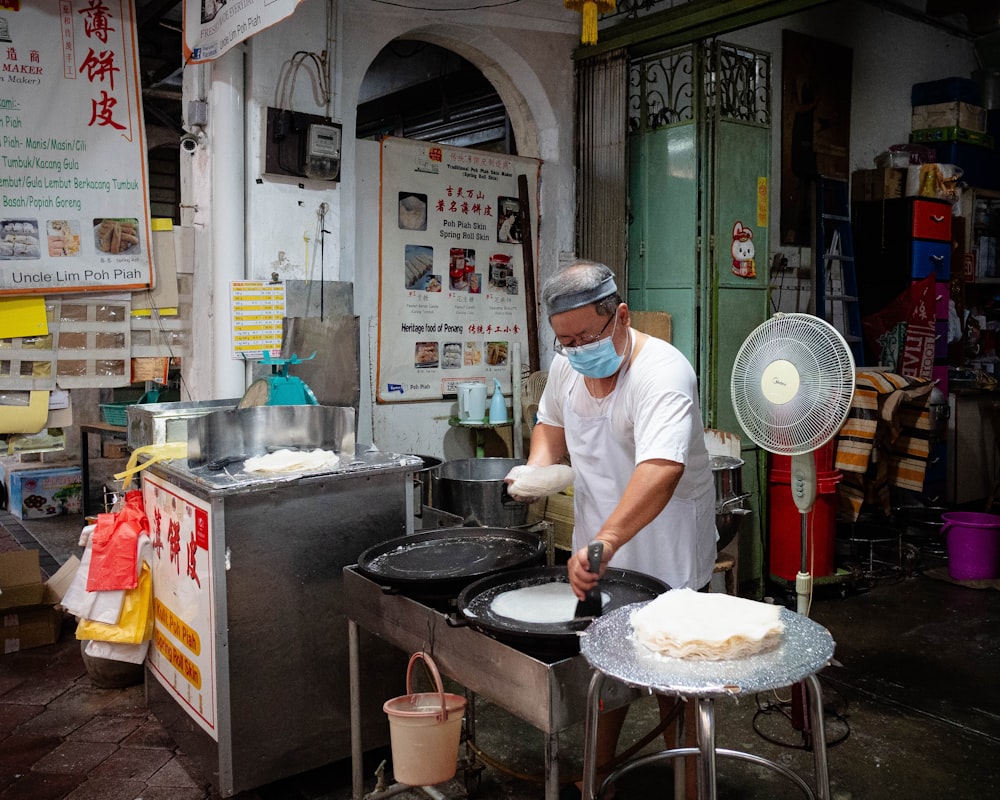 a man wearing a face mask is making food