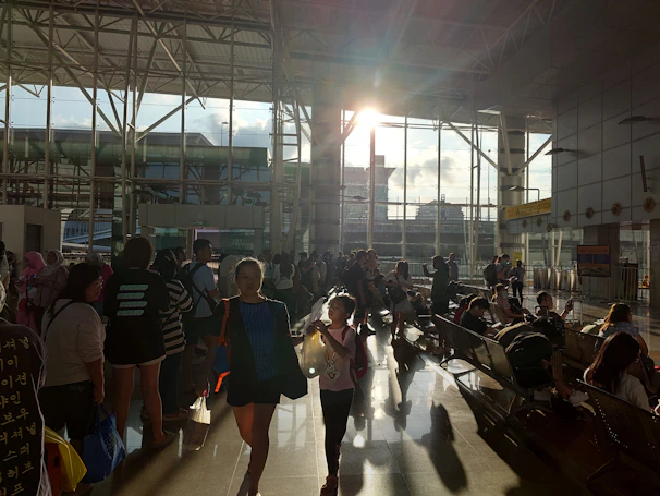 A cinematic view of a male travel creator filming at a bustling international airport terminal