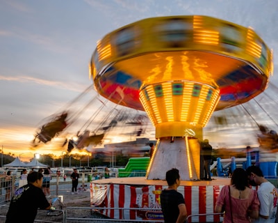 a carnival ride with people standing around it