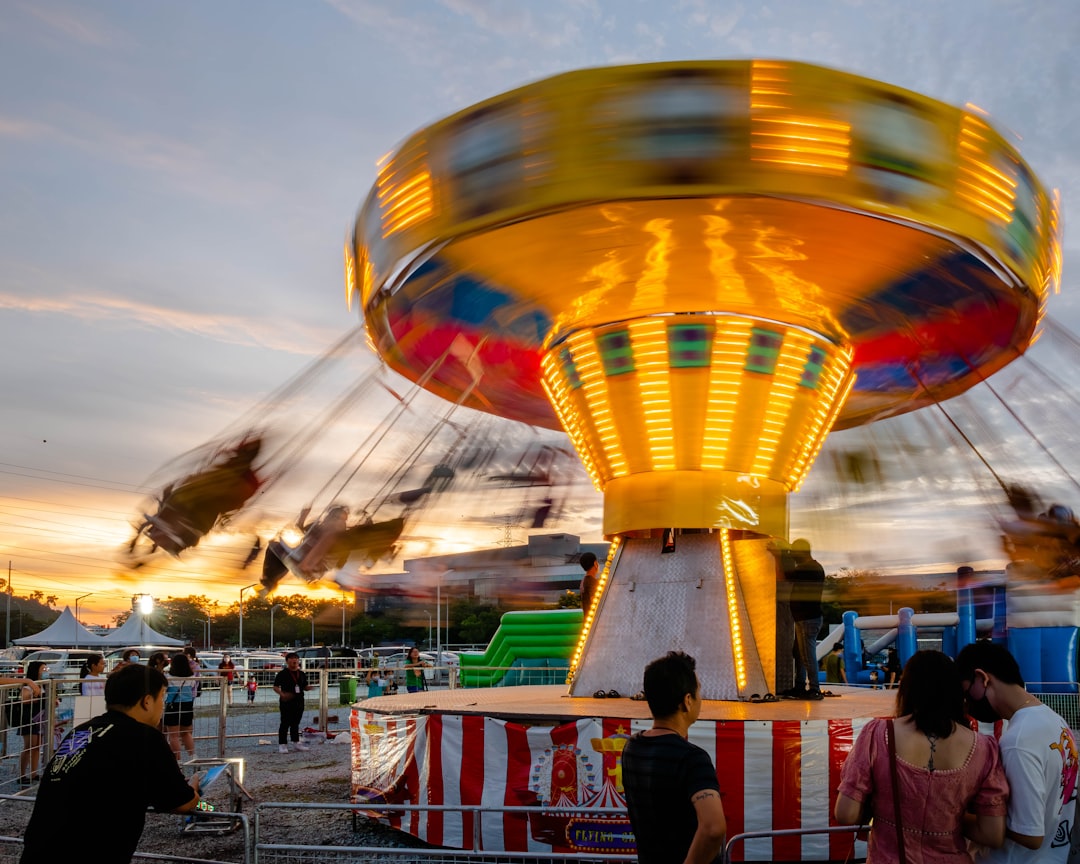 a carnival ride with people standing around it,