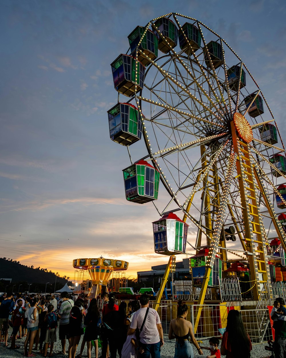 a large ferris wheel sitting next to a crowd of people