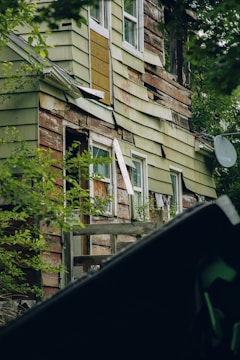 Photo of an older single-family home with worn siding and overgrown lawn in Utah neighborhood.