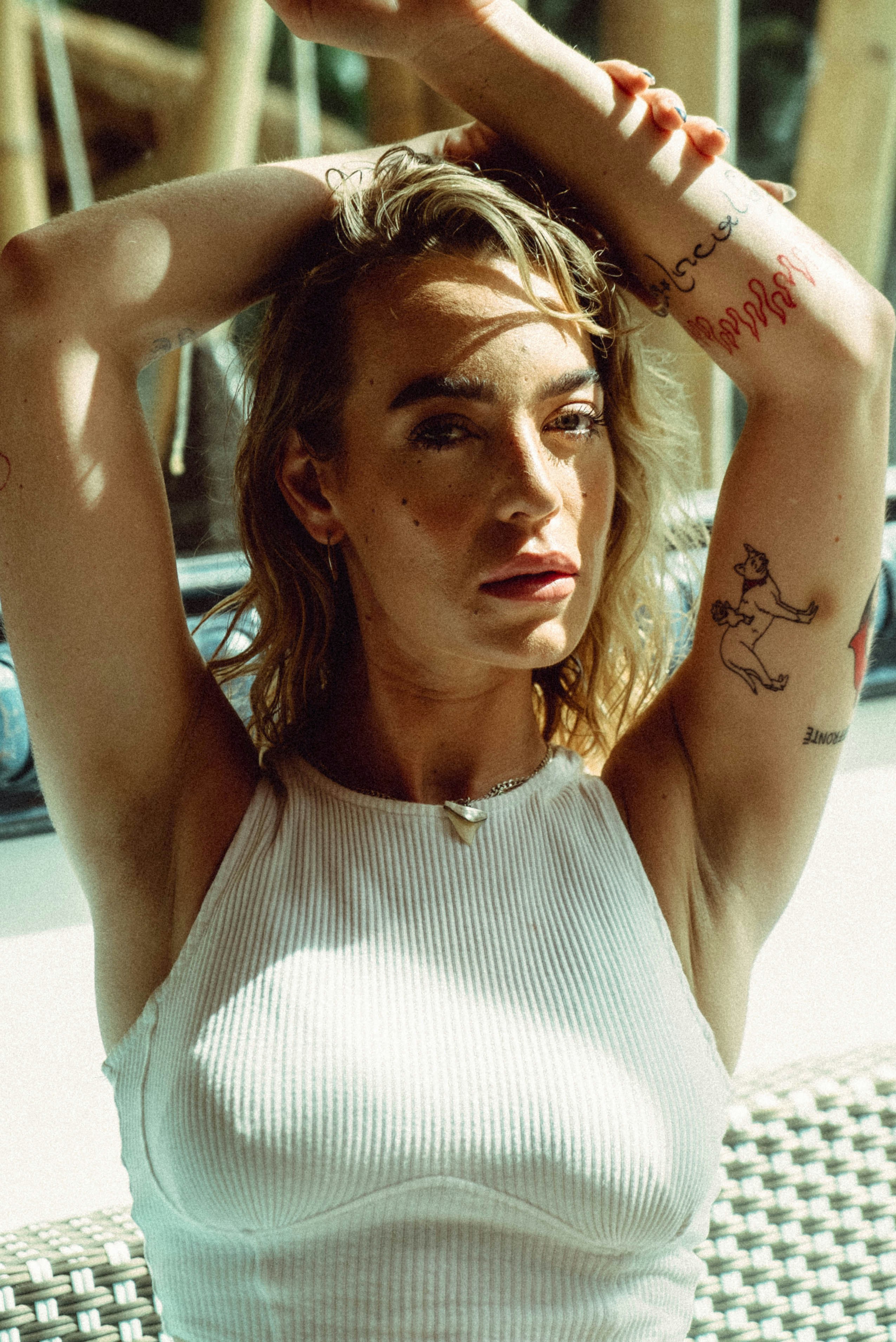 eine frau, die auf einer bank sitzt, die hände hinter dem kopf verschränkt