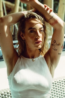 a woman sitting on a bench with her hands behind her head