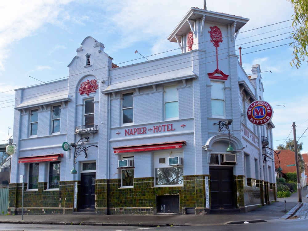 a large white building with a red and white sign on the front of it