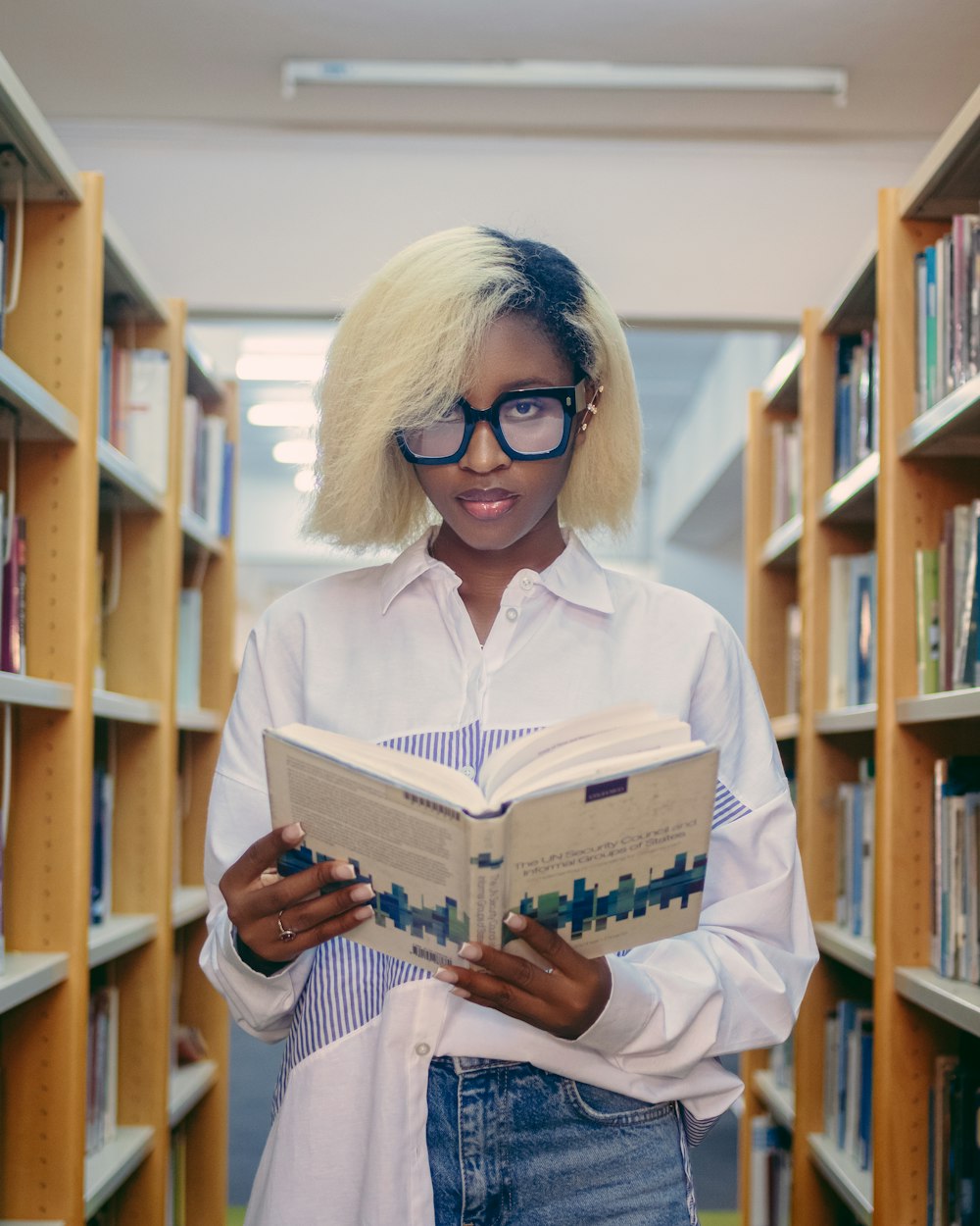 a woman reading a book in a library