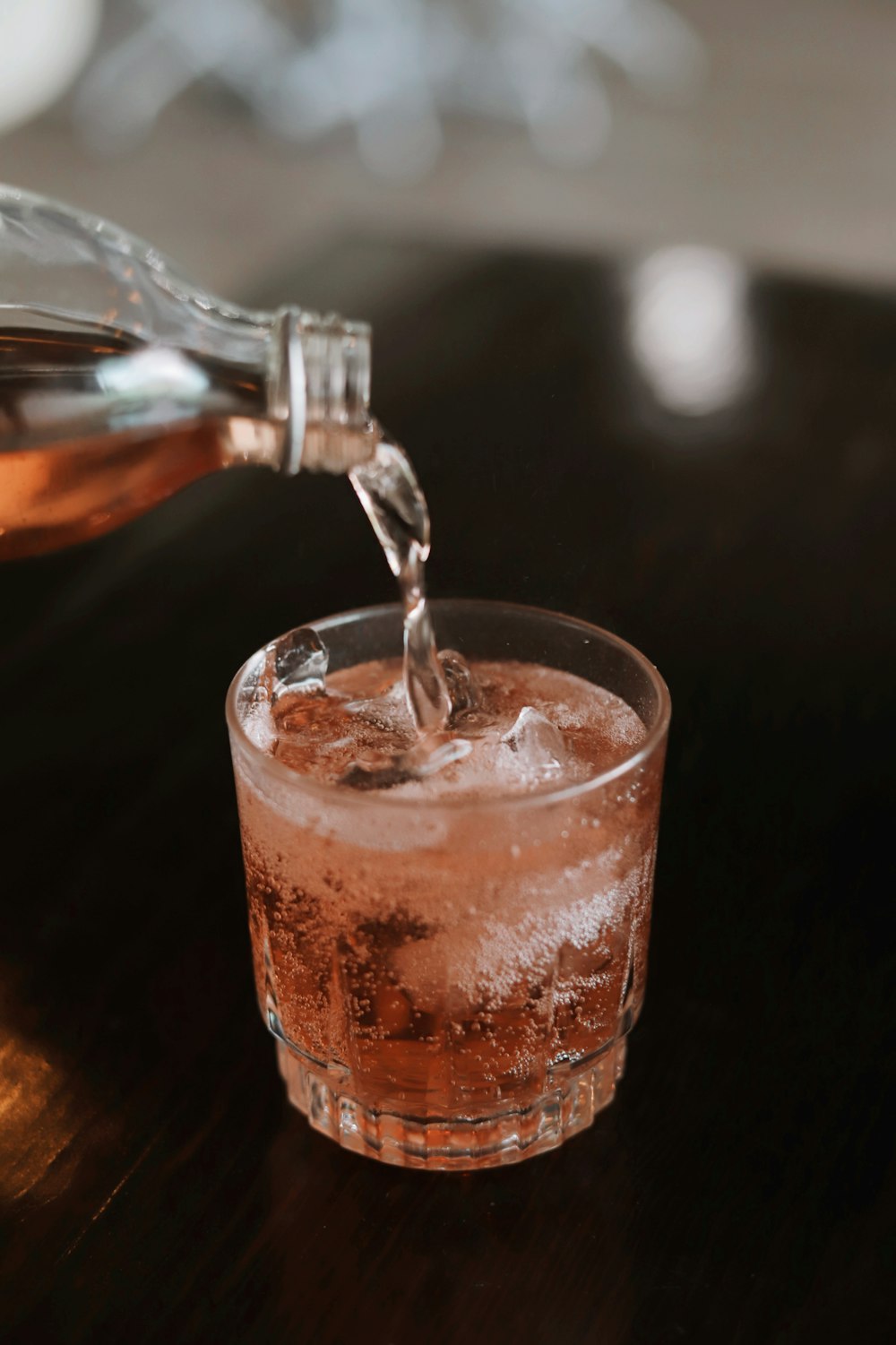 a glass filled with ice and water on a table