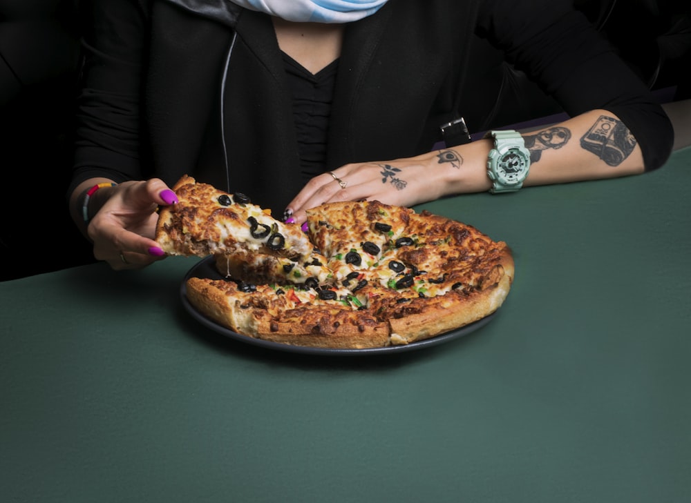 a woman eating a slice of pizza on a plate