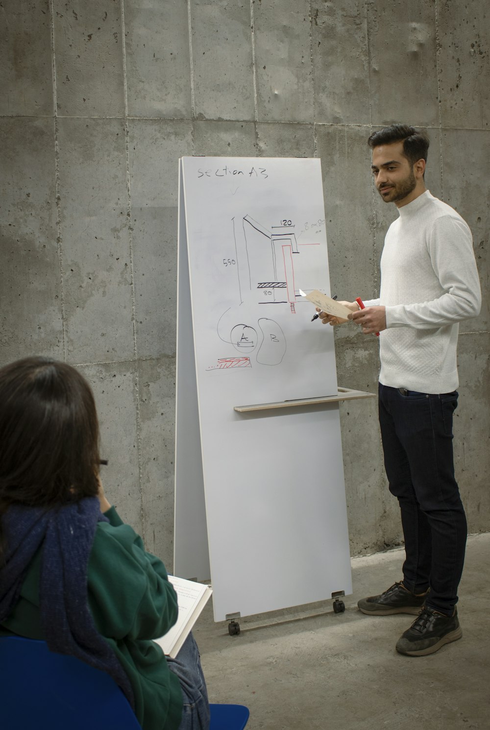 a man standing in front of a white board