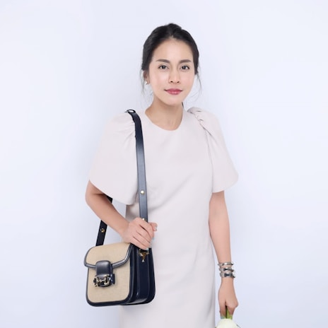 A model holding a simple yet elegant pandan bag styled with casual modern clothing.