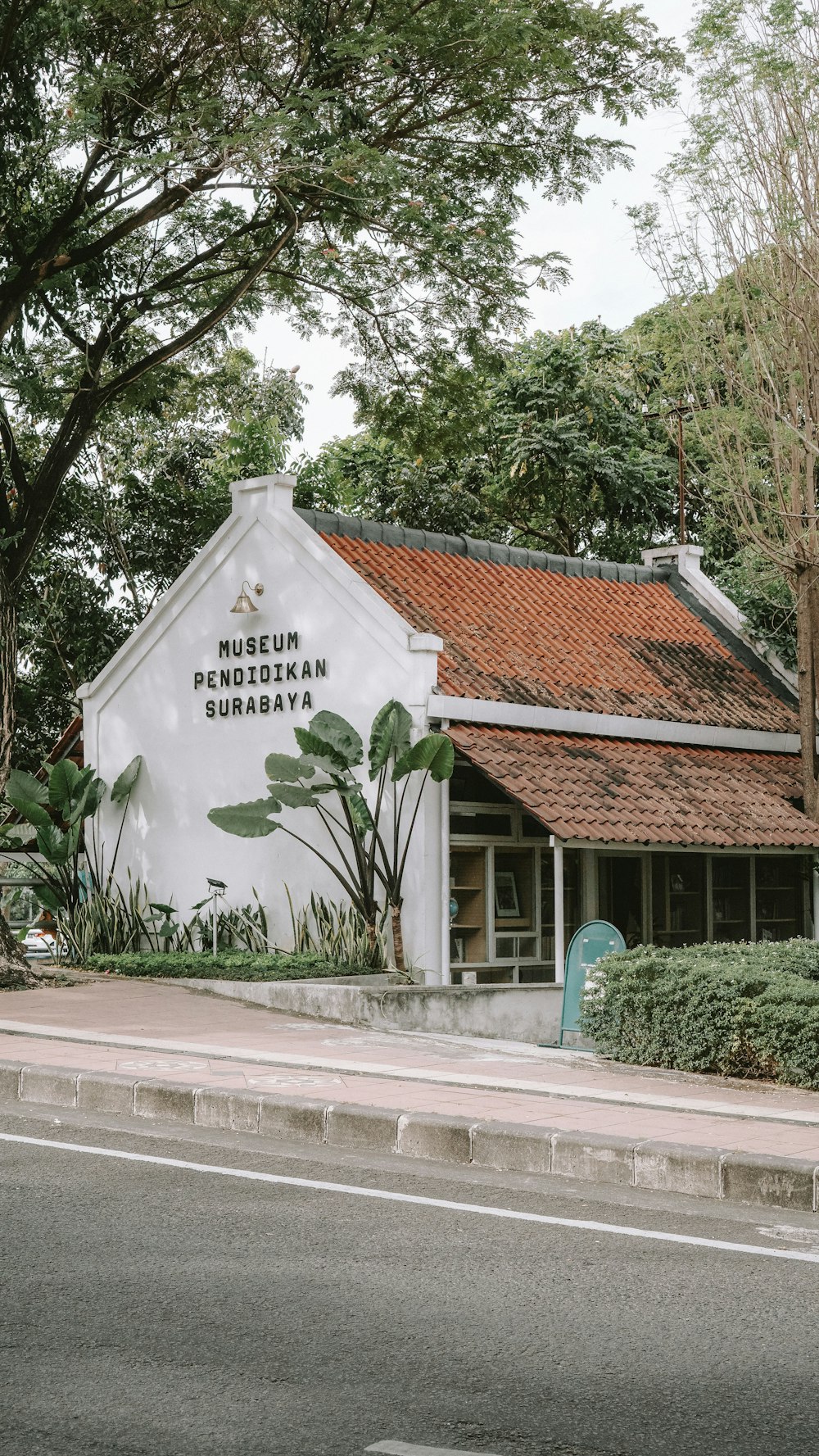 a white building sitting next to a lush green forest