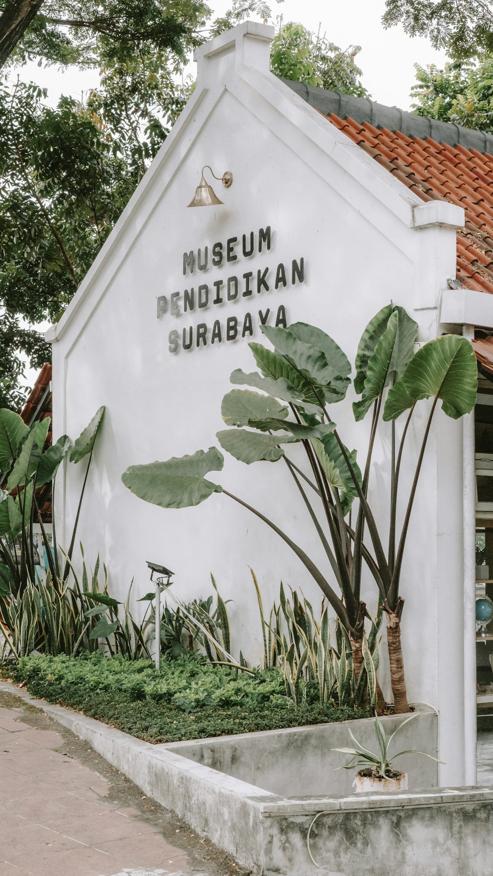 Un edificio blanco con un letrero que dice Museo Pendididikan Suraba